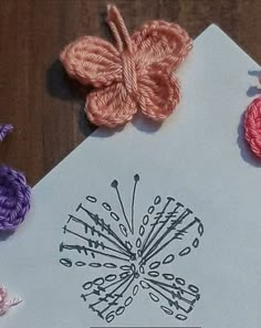 some crocheted flowers are sitting on top of a piece of paper