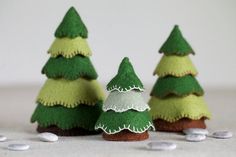 three small felt christmas trees sitting next to each other