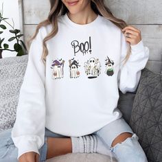 This Halloween, get ready to show off your spooky vibes with this groovy ghost-themed sweatshirt! Featuring cute ghosts, witches, and other spooky characters, this sweatshirt is perfect for the spooky season. The bright colors and fun designs will make you look cute and stylish while still embracing the spirit of Halloween. Trick or treat in style with this spooky ghost-themed sweatshirt! The perfect way to show off your love of all things spooky, creepy, and boo-tiful. Get ready to have a happy Trendy Fall Hoodie With Character Print, Oversized Fall Sweatshirt With Character Print, Trendy White Halloween Hoodie, Fall Character Print Relaxed Fit Sweatshirt, Trendy White Halloween Sweatshirt, White Graphic Print Sweatshirt For Halloween, White Long Sleeve Halloween Sweatshirt, Fun Long Sleeve Sweatshirt With Character Print, Trendy Fall Sweatshirt With Character Print