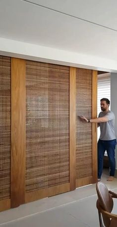 a man standing in front of a sliding door with wood slats on the wall