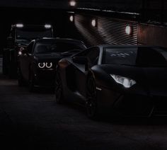 three black sports cars parked side by side in the dark