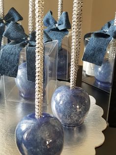 two blue balls are sitting on a table with silver beading and bowknots