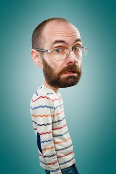 a man with glasses and a beard is looking at the camera while wearing a sweater