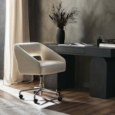 an office chair sits in front of a desk with a plant on it and a book