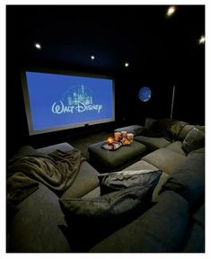 a movie theater with two couches and a projector screen in the middle of it