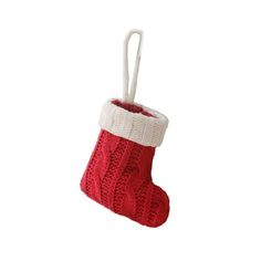 a red and white knitted stocking hanging from a string on a white background