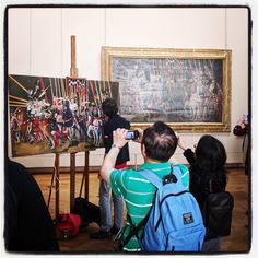 a group of people taking pictures of an art work