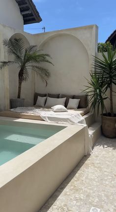 an outdoor swimming pool surrounded by potted plants