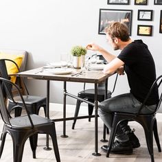 a man sitting at a table with two chairs