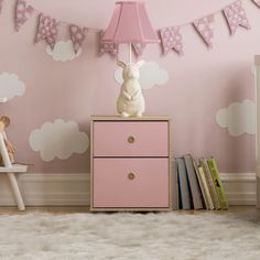 a baby's room decorated in pink and white with clouds on the wall, including a bunny lamp