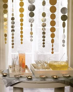 the table is set with champagne glasses and confetti hanging from the windowsill