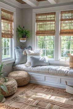 a window seat with pillows on it in a room filled with windows and rugs