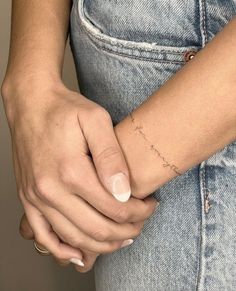 a woman's arm with a small tattoo on it