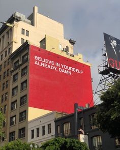 an advertisement on the side of a building that says believe in yourself already, damn