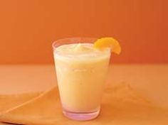 a glass filled with orange juice sitting on top of a table