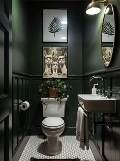 a bathroom with a toilet, sink and pictures on the wall in it's corner