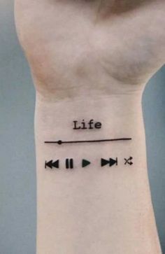 a wrist tattoo with the words life and arrows on it