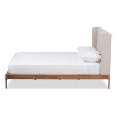 the bed is made up with white sheets and pillows on it's headboard