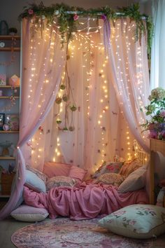 a bedroom with fairy lights hanging from the ceiling and pink bedding on the walls