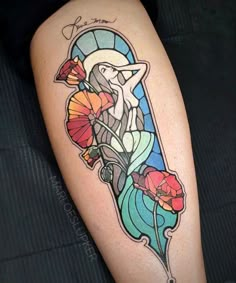 a woman's leg with flowers on it and a stained glass window in the background