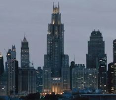 the city skyline is lit up at night with skyscrapers in the foreground and lights on