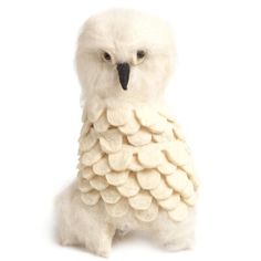 a white stuffed owl sitting in front of a white background