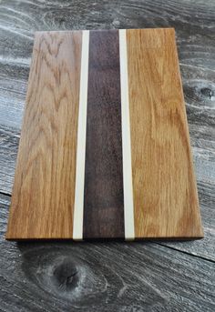 a wooden cutting board sitting on top of a wooden table next to a piece of wood