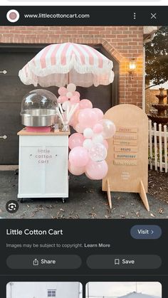 the little cotton cart has pink balloons and an umbrella in front of it, along with other items