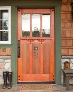 a pair of well worn boots sit in front of a wooden door with sidelights