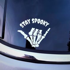 a sticker on the side of a car that says stay spooky with two hands