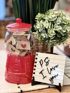 a red gumper machine sitting on top of a table next to a vase filled with flowers