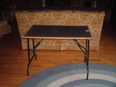 a table sitting on top of a wooden floor next to a couch