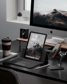 an apple computer sitting on top of a desk next to a laptop and phone holder