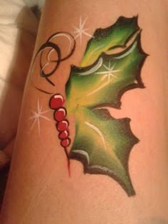 a tattoo with holly leaves and stars on it