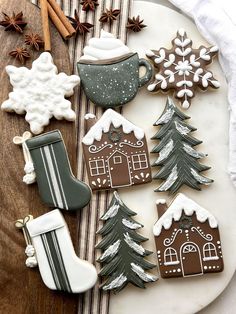 decorated cookies are arranged on a platter with cinnamon sticks and an ornament