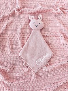 a pink blanket with a stuffed animal on it