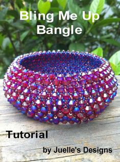 a purple and red beaded bowl sitting on top of a wooden table