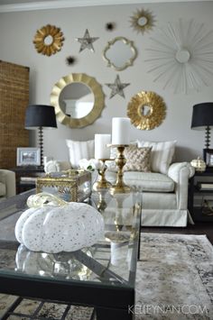 a living room filled with furniture and mirrors on the wall above it's coffee table