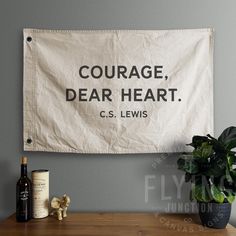 Courage Dear Heart C.S. Lewis hand painted cotton canvas flag / banner Customized version of this flag available here: https://www.etsy.com/listing/1102201014/ - 10oz Duck Cloth, 100% Cotton - Hand cut & sewn in USA - Hand painted with non-toxic paint - Dull black grommets - Allows for vertical or horizontal hanging For more options (including logos, alternate layouts, colors, and font choices), please visit my website or send me a message. Please note: because these are cut & sewn by hand, finished sizes may vary slightly - 5%). Canvas Tapestry, Wall Tapestry Bedroom, Canvas Flag, Paint Brass, Canvas Banner, Wall Flag, Decor Quotes, Home Decor Quotes