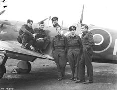 an old black and white photo of men in uniform standing next to a small plane