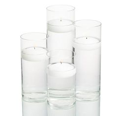 several clear glass vases with candles in them