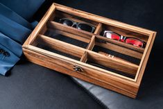 an open wooden box containing pairs of glasses