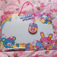 a pink and white mouse pad with a cute cartoon character on the front, next to a matching keychain