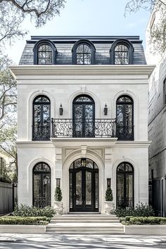 a large white house with black windows and balconies