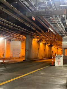 an empty parking garage with no cars or people in it and signs on the wall