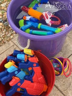 a bucket full of toys sitting on the ground