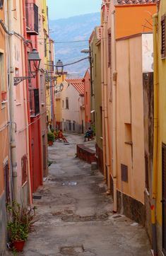 an alley way with many buildings on both sides and mountains in the backgrouds