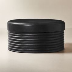 a black round stool sitting on top of a table