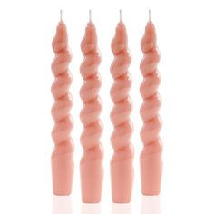 three pink candles are lined up in the shape of spirals on a white background