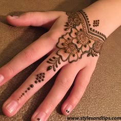 a woman's hand with henna tattoos on it